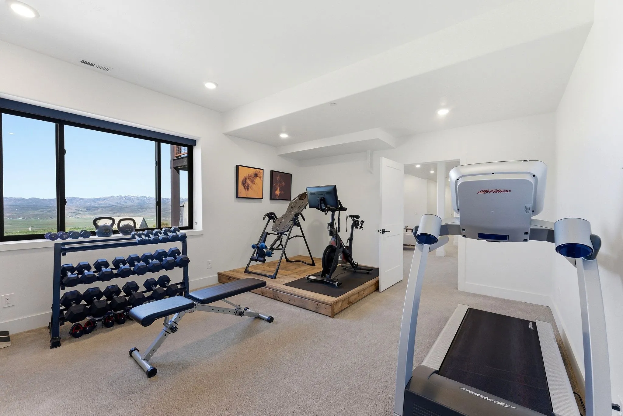 Dedicated fitness space featuring a large window with distant mountain scenery