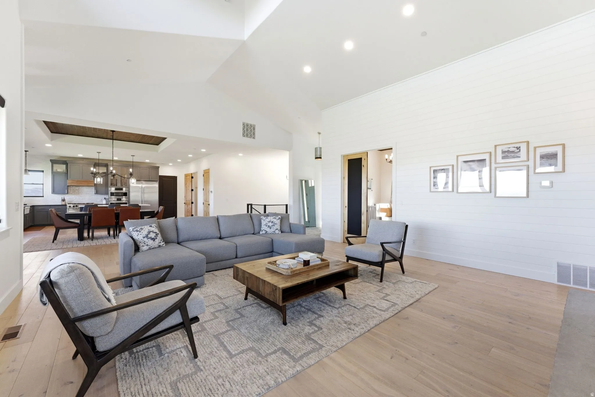Spacious living area featuring light wood-finish flooring and a high vaulted ceiling