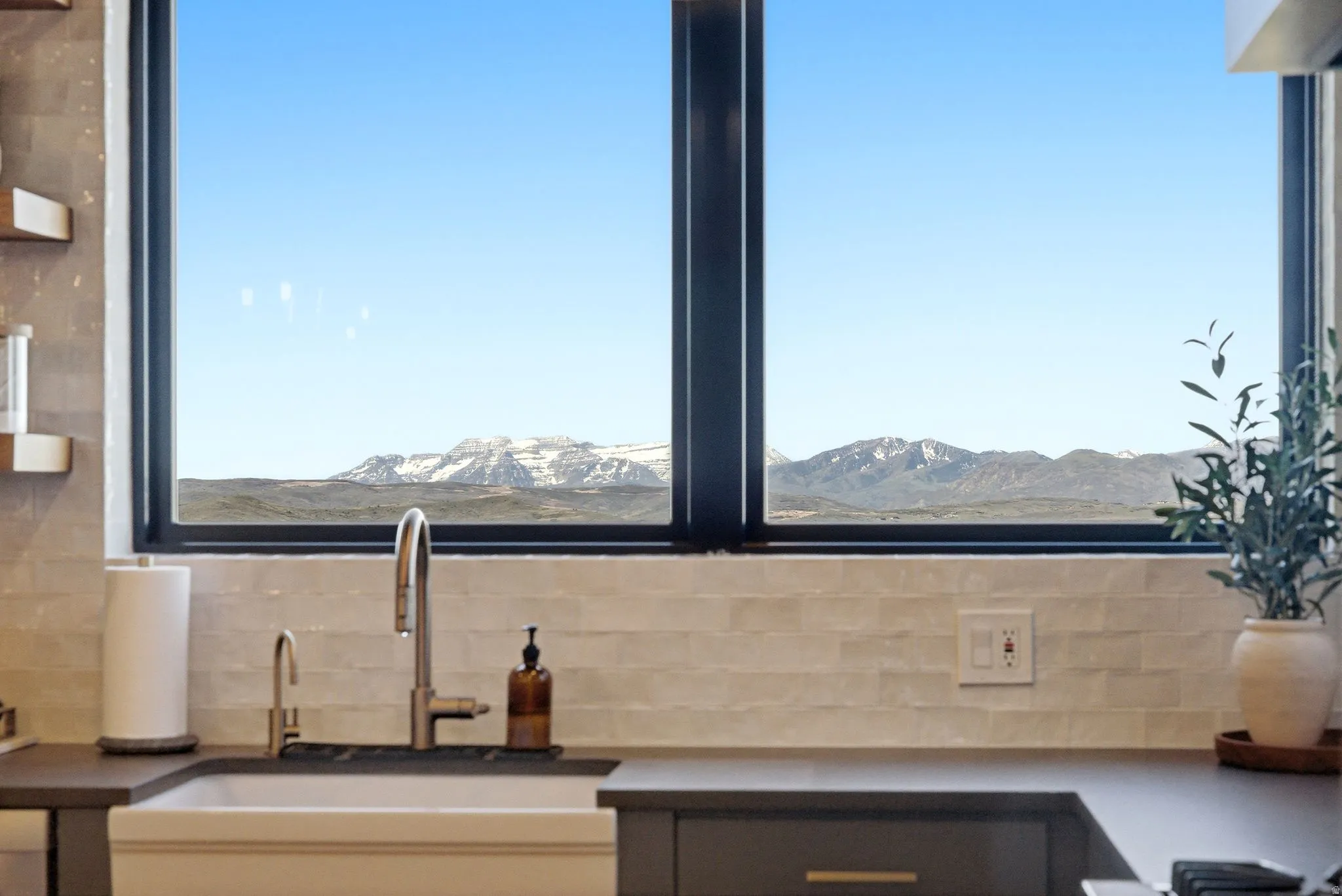 Large picture window framing distant snow-capped mountains