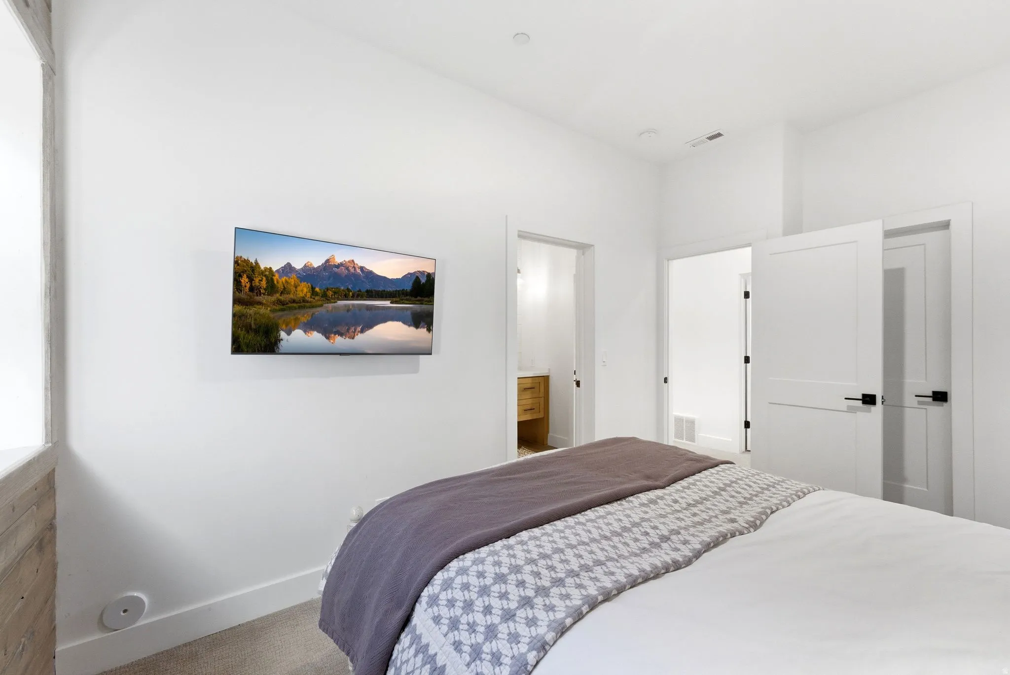 Bright interior space featuring white walls and a mounted television