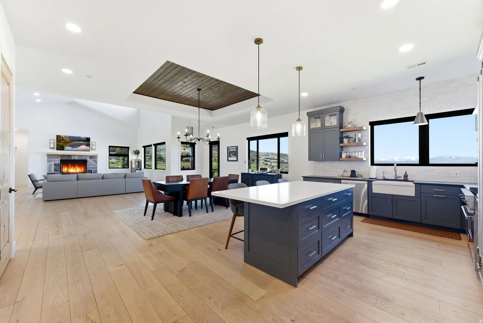 Open-concept living space featuring light wood-finish flooring, a vaulted ceiling, and recessed lighting