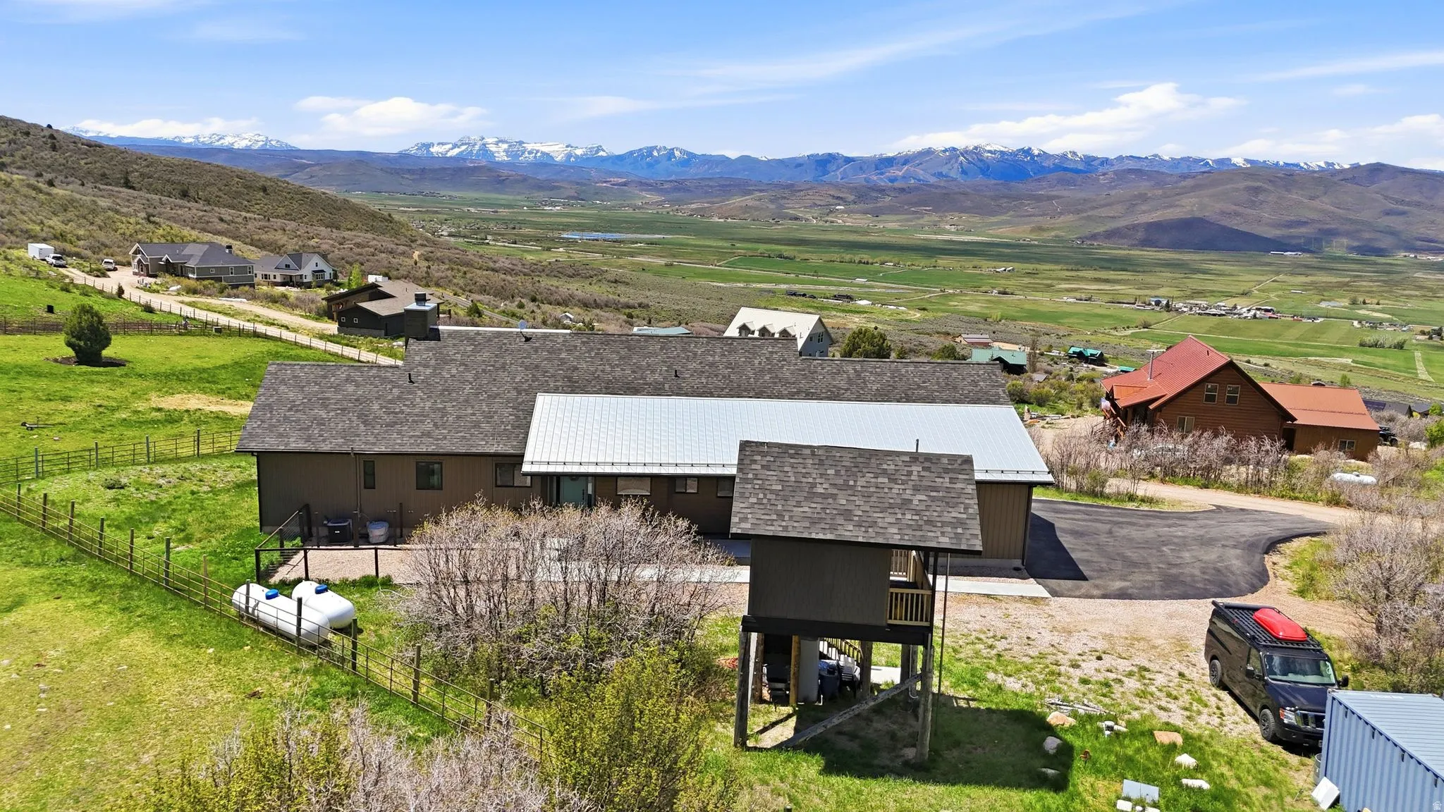 Expansive property with a brown-toned exterior, a shingled roof, and a metal roof section