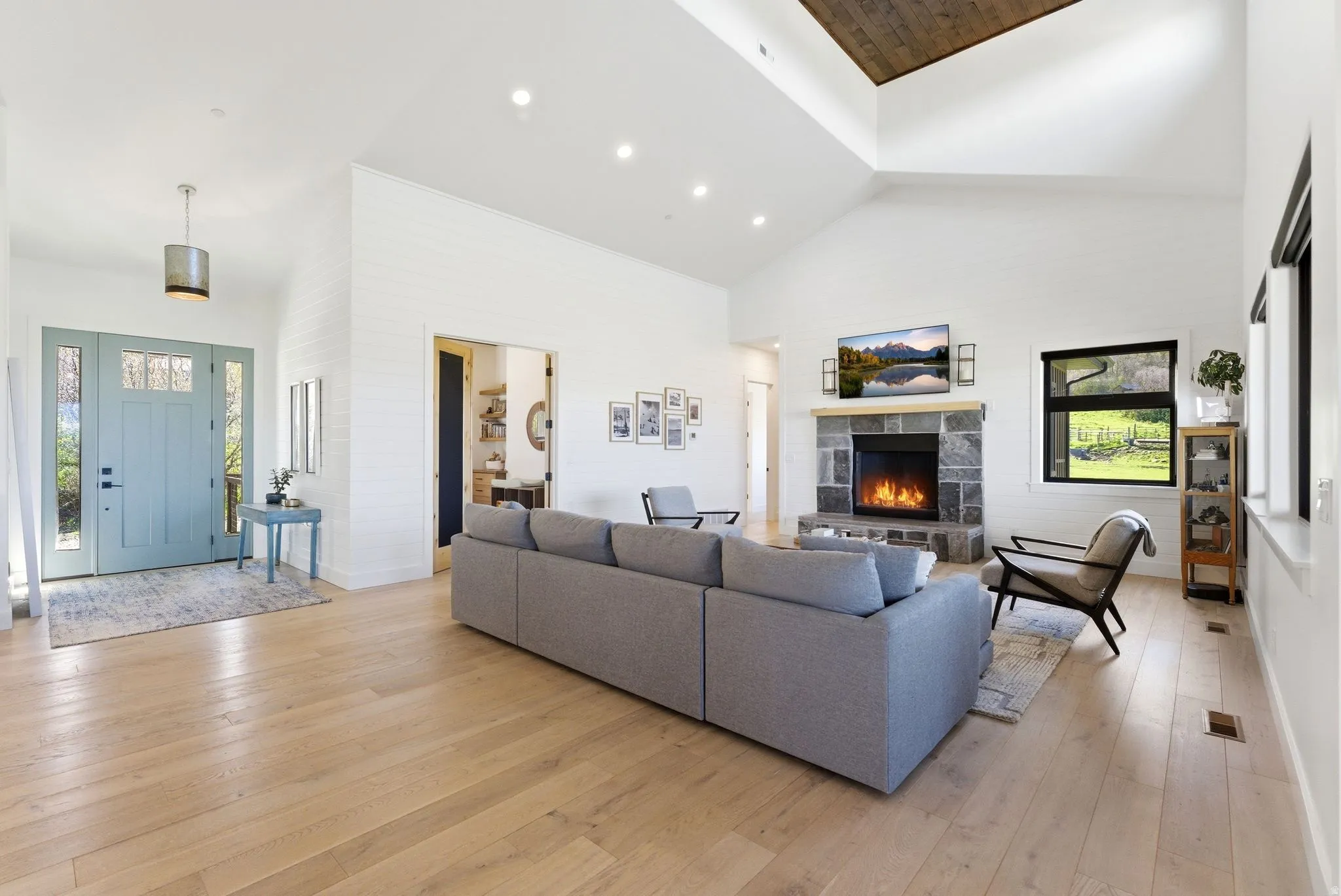 Expansive living area with vaulted ceilings and wood-finish flooring