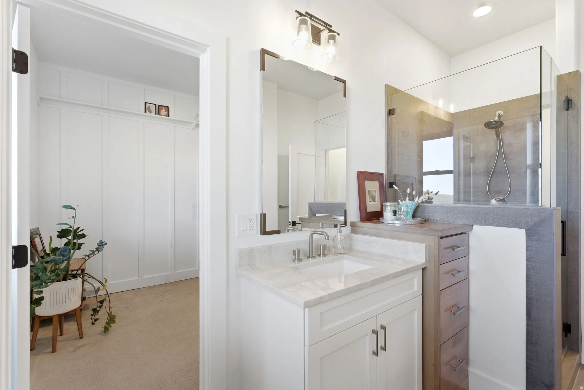 Bathroom featuring a single vanity with stone countertop, undermount sink, and brushed nickel faucet