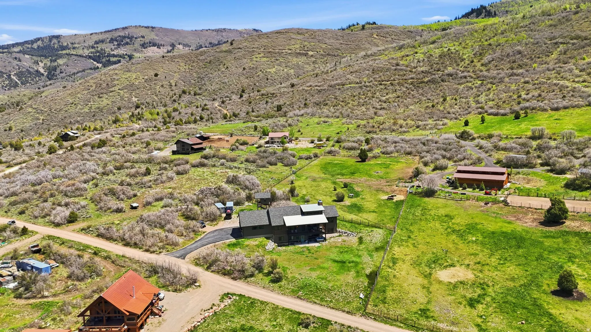 Expansive property featuring a multi-level residence with a dark roof and paved driveway
