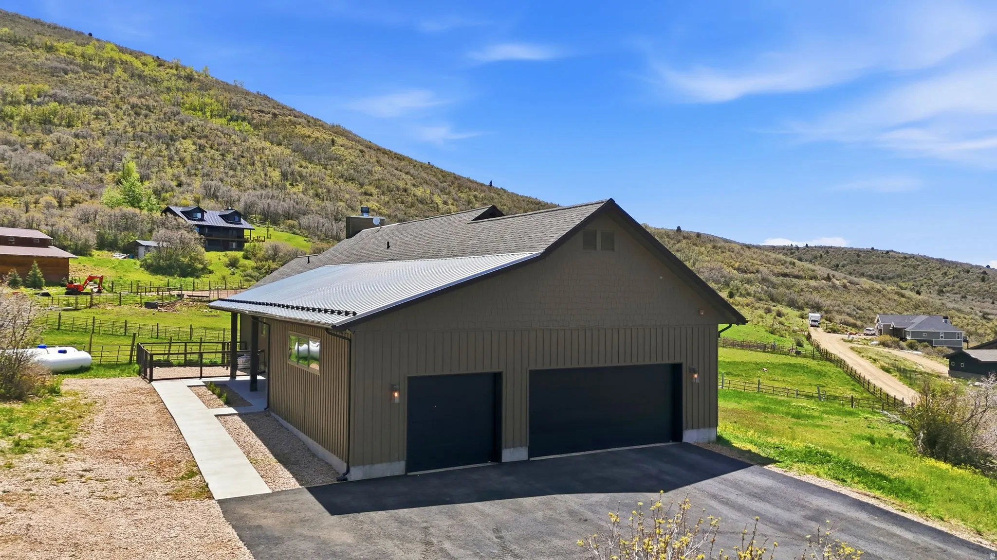 Modern residence with a two-car garage, asphalt driveway, and a covered porch