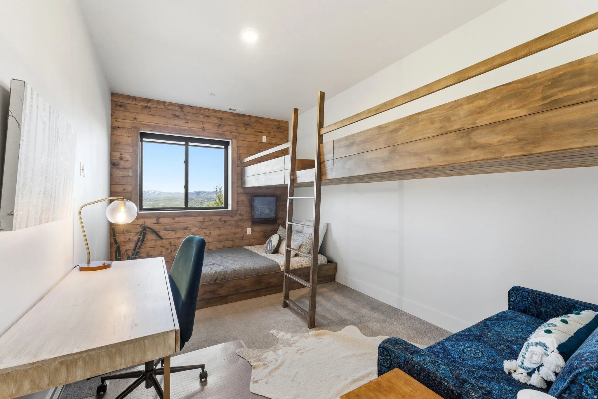 Bedroom featuring a built-in bunk bed system, a wood-paneled accent wall, and a large window