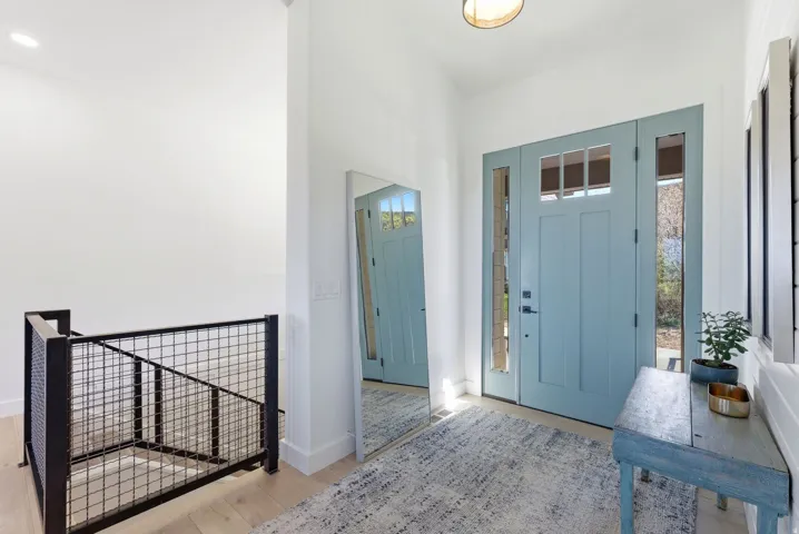 Light blue front door with transom windows and sidelights