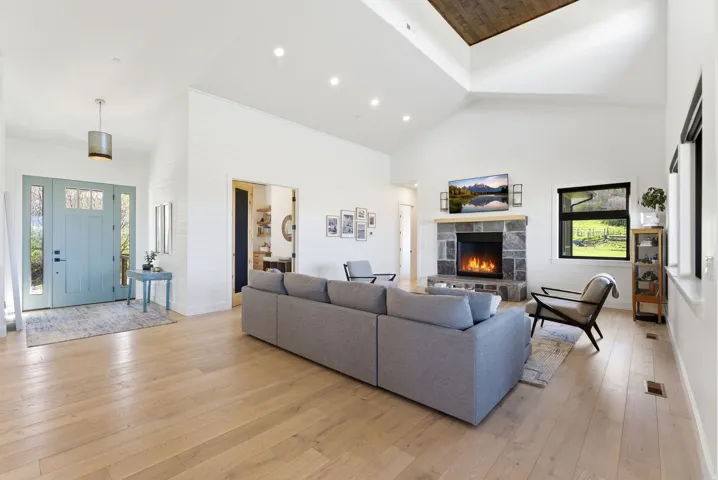 Expansive living area with vaulted ceilings and wood-finish flooring