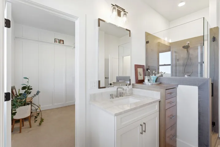Bathroom featuring a single vanity with stone countertop, undermount sink, and brushed nickel faucet