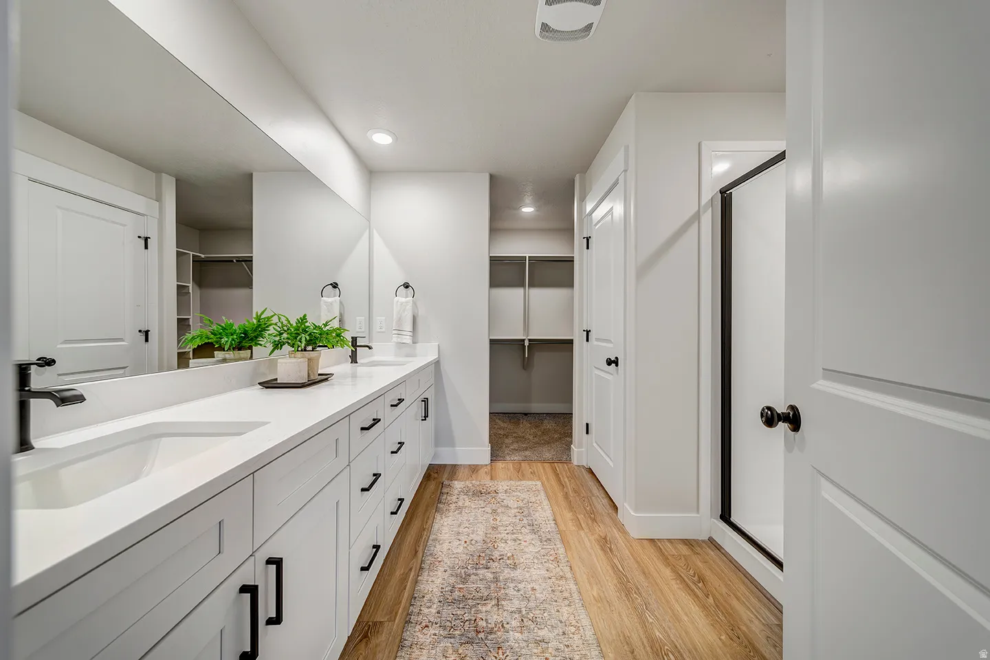 Dual vanity with integrated sinks and black matte fixtures, set against a full-width mirror