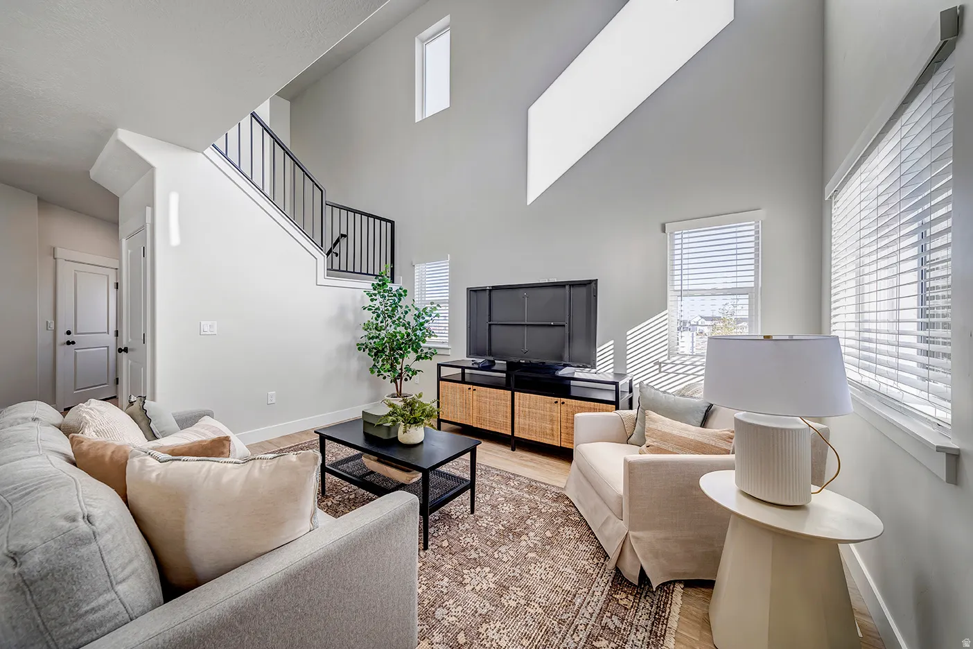 Vaulted ceilings with a high-set transom window and a contemporary staircase featuring black metal railings