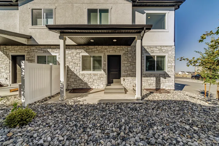 Stone veneer and stucco exterior with a covered porch entry