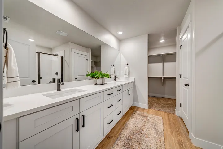 Dual vanity with white shaker cabinetry, white countertops, and matte black plumbing fixtures