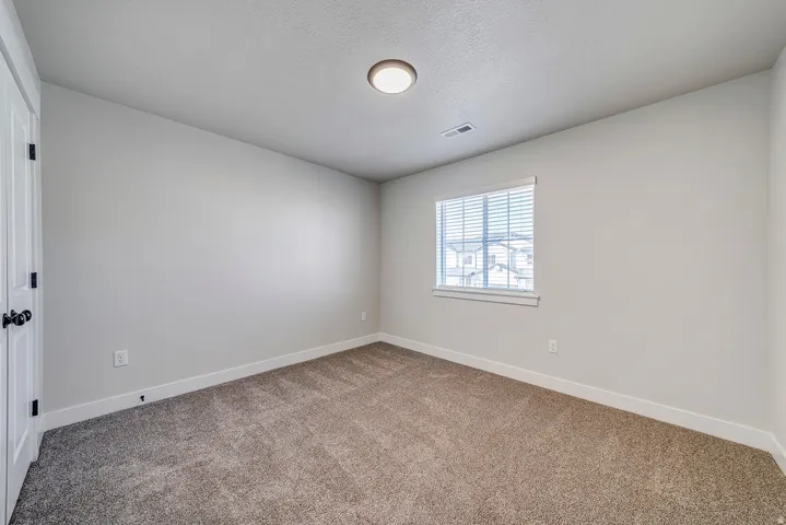 Carpeted interior room with light neutral wall paint