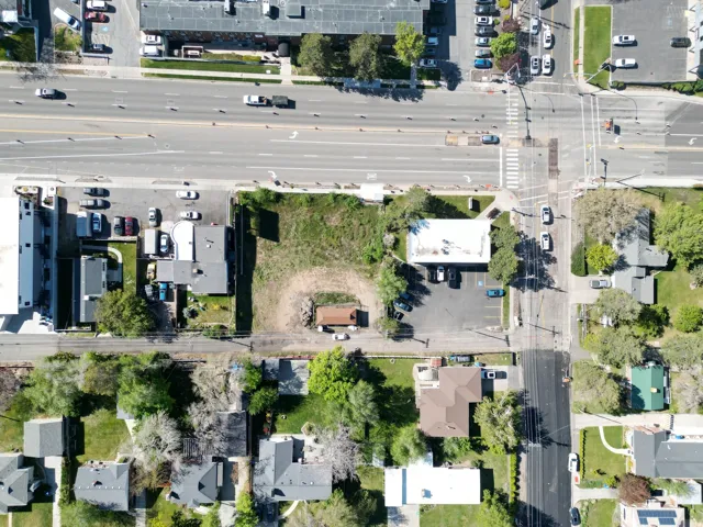 Expansive land parcel featuring direct frontage on a multi-lane roadway, existing commercial structures, and a clear, level buildable area