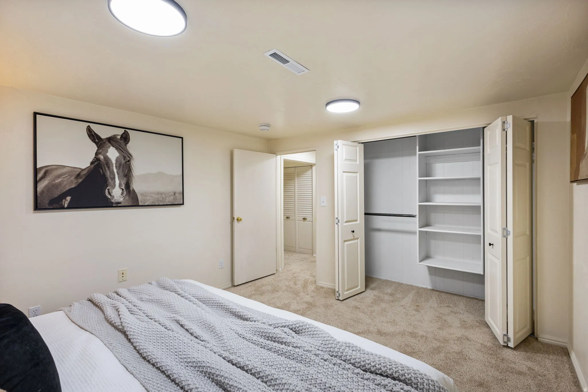 BedrooCarpeted room featuring two recessed windows, neutral wall color, baseboard trim, and flush-mount ceiling lighting. Basement Bedroom #1- View #2.