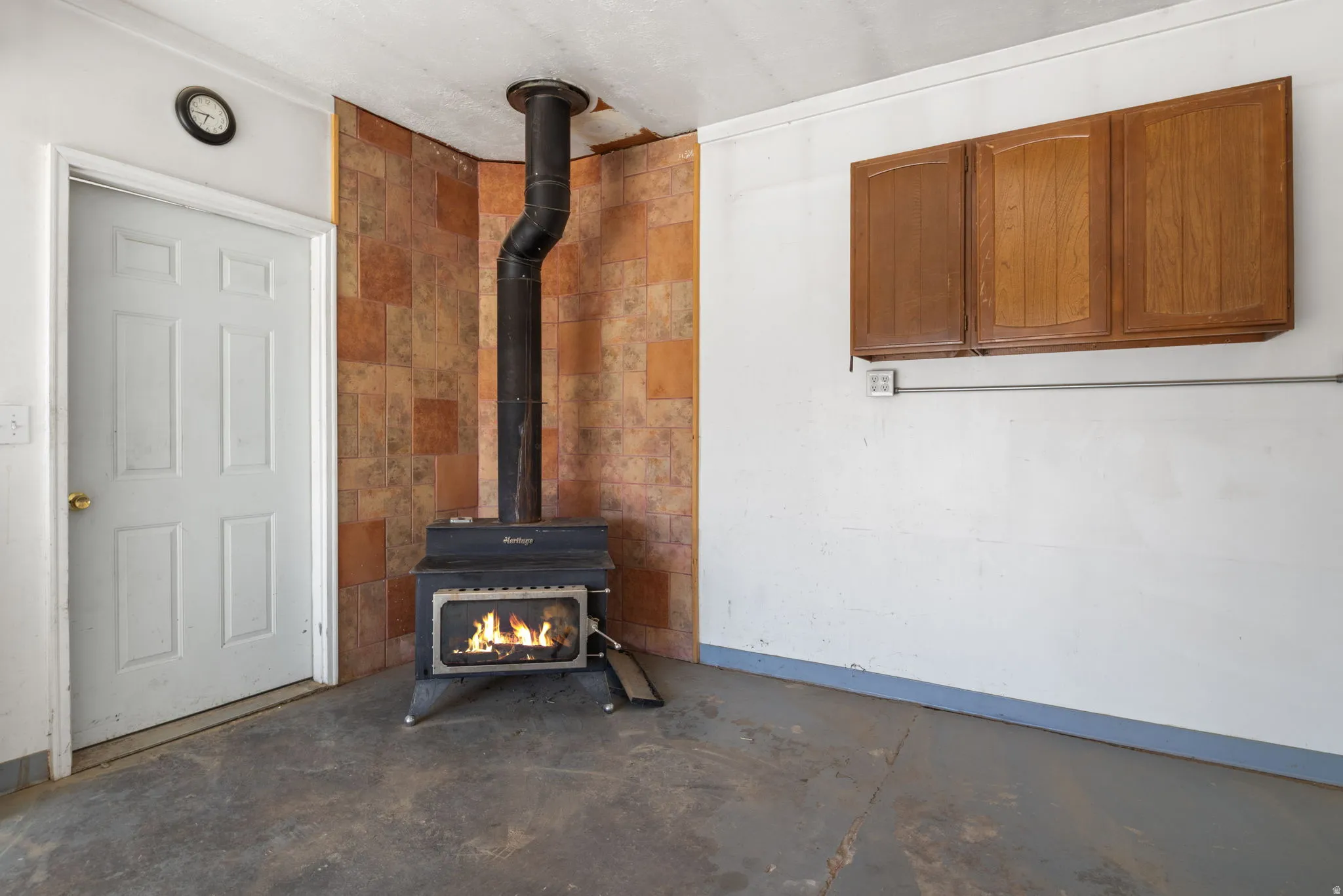 Freestanding wood-burning stove with a tiled back wall.