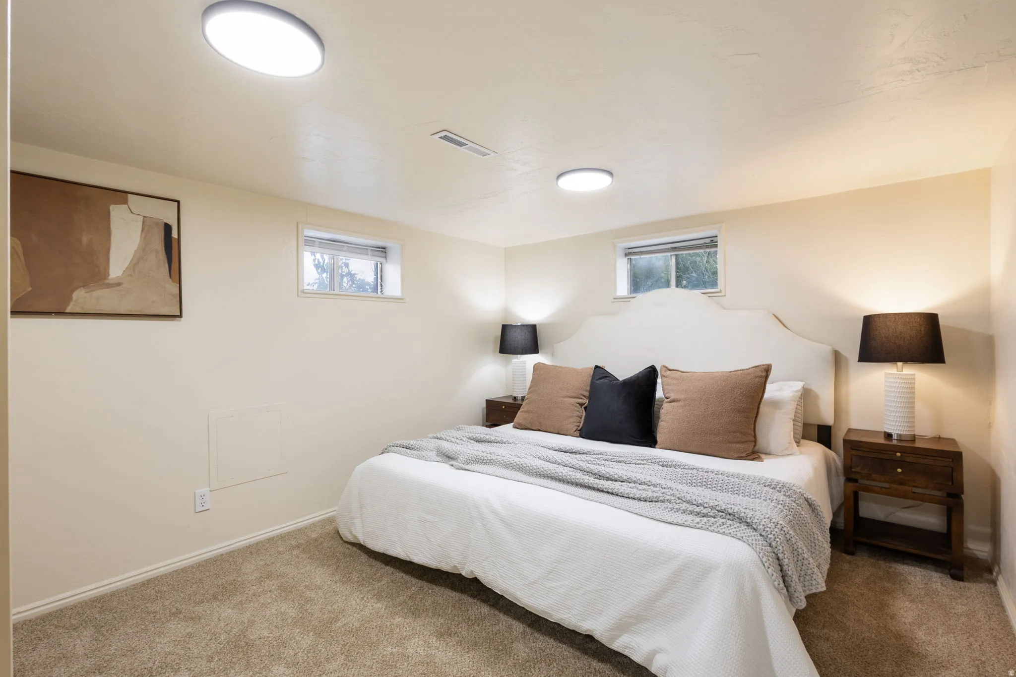 Neutral-toned carpeting and walls complement the bright overhead lighting. Basement Bedroom #1-View #1.