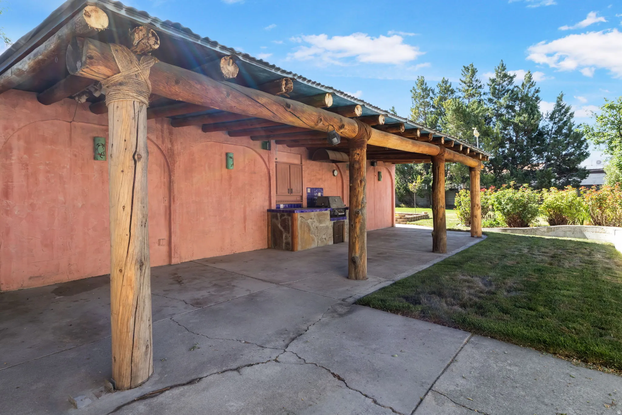 Expansive covered patio featuring natural wood posts and exposed log ceiling beams.