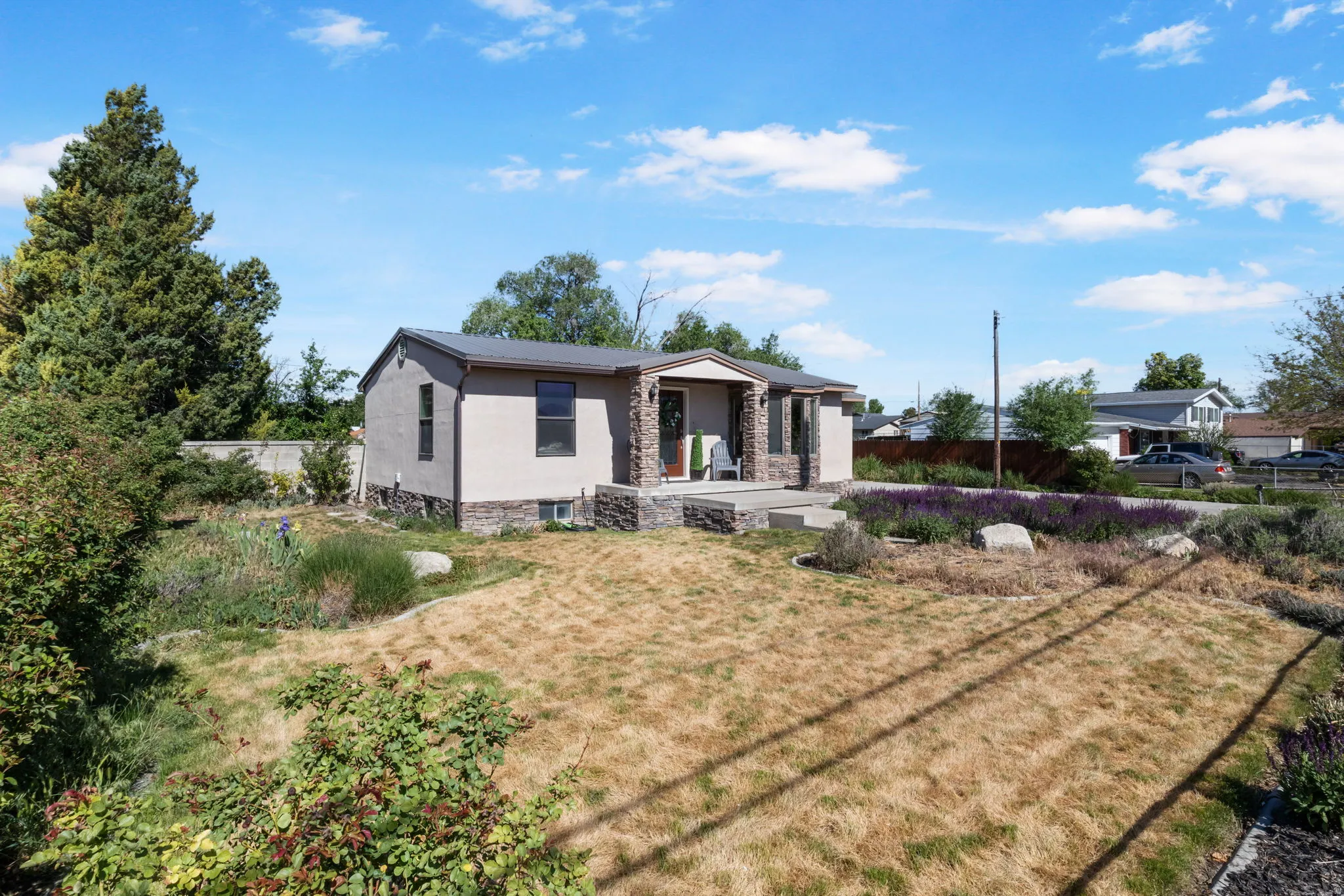 Single-story residence featuring stucco siding and a covered entry with stone accents.