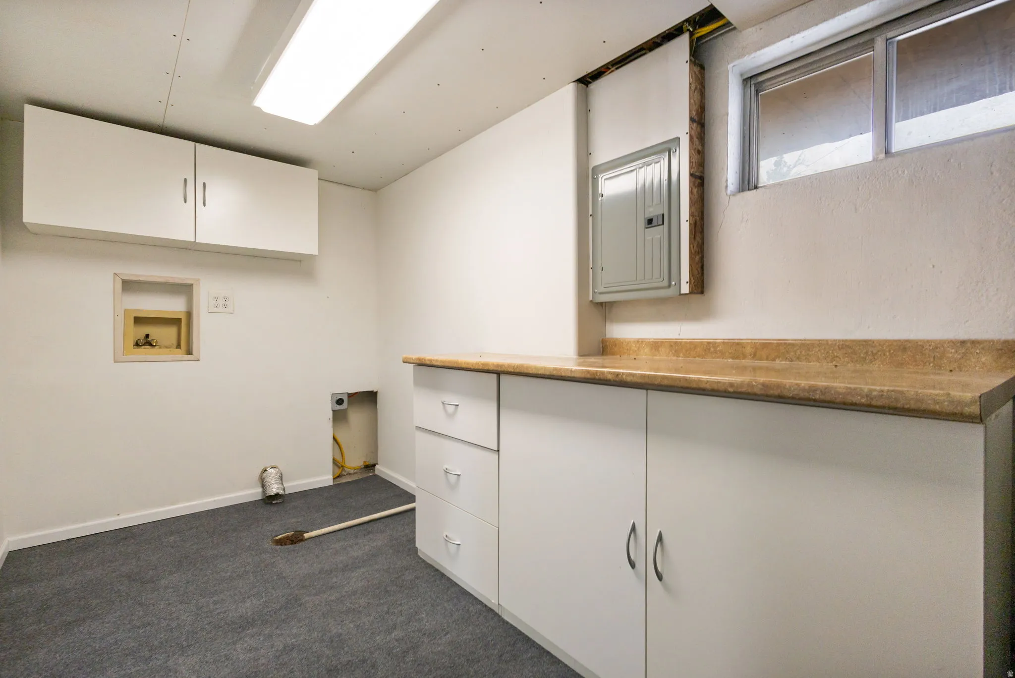 Laundry area featuring white cabinetry, a light-colored countertop, and a utility window-View #1
