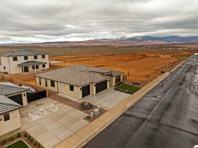 New construction residence featuring a neutral stucco exterior, a tiled roof, and a concrete driveway