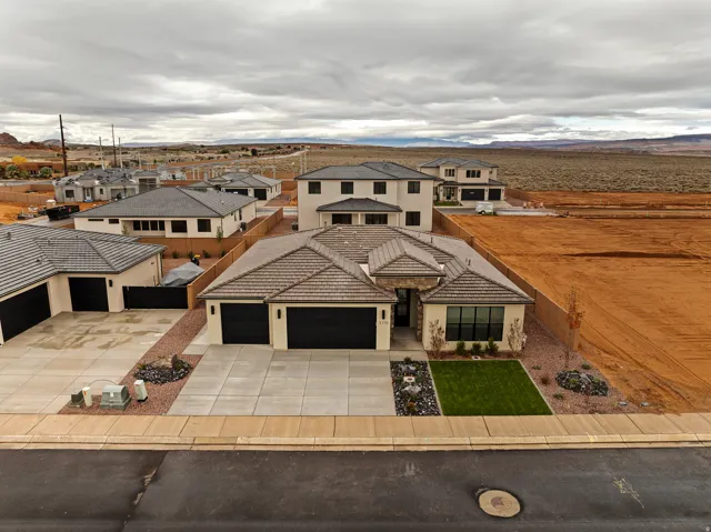 Contemporary single-story residence featuring a neutral stucco exterior, a tiled roof, and an attached two-car garage