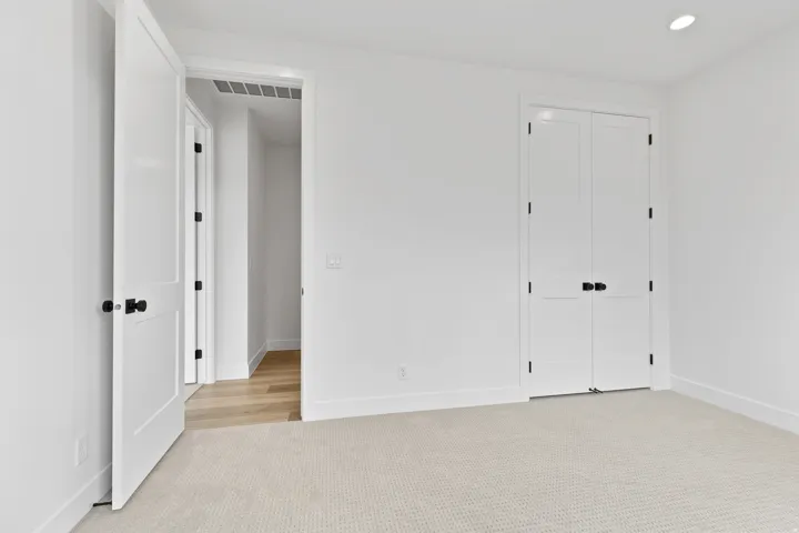 Carpeted interior space featuring crisp white walls and white trim