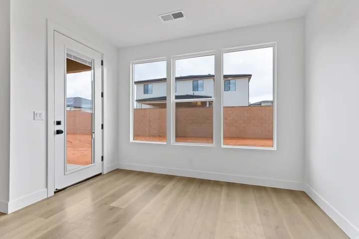 Light wood-finish flooring complements the bright white walls and trim