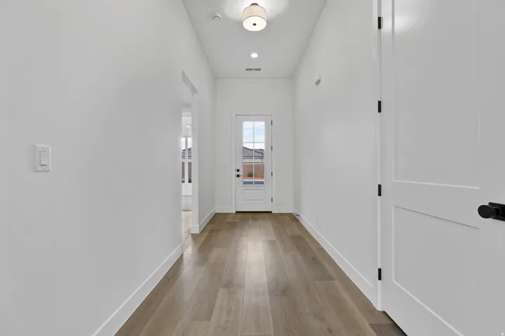 Entryway featuring wood-finish flooring, white walls, and a contemporary flush mount light fixture