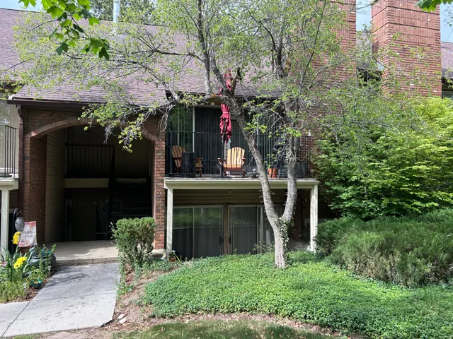 Brick exterior with a dark shingle roof and an arched entryway