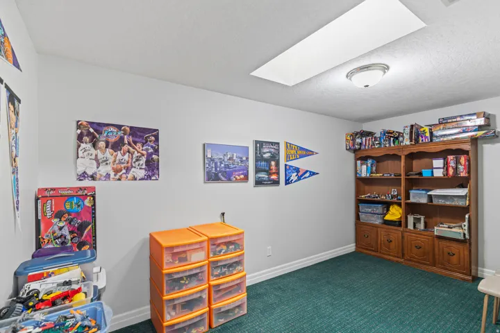 Game room featuring a skylight, dark carpet, and a textured ceiling