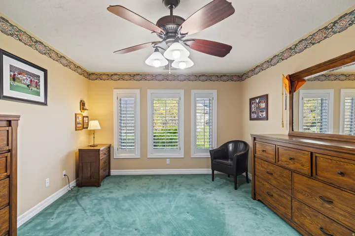Sitting room featuring light carpet, a ceiling fan, healthy amount of natural light, and a textured ceiling