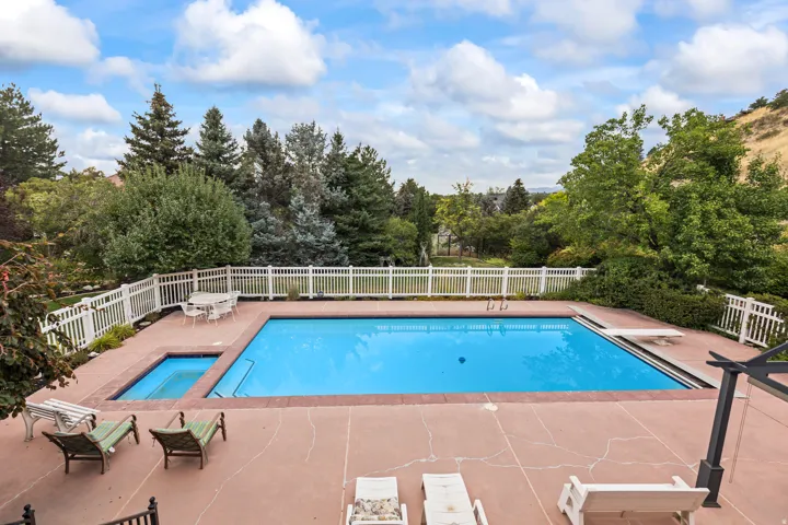 View of pool with patio surround and view of wooded area