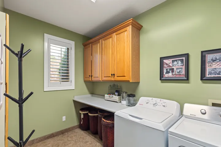 Laundry room featuring independent washer and dryer, light tile patterned flooring, and cabinet space