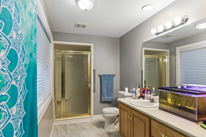 Full bathroom featuring a stall shower, vanity, and light marble finish floors