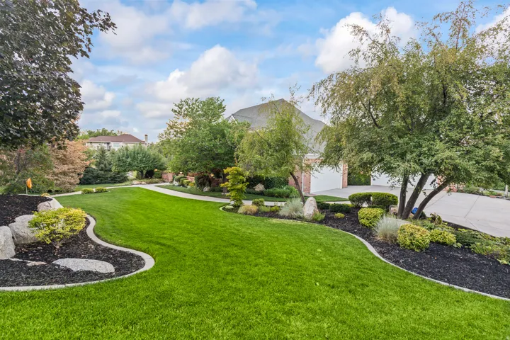 View of green lawn featuring driveway