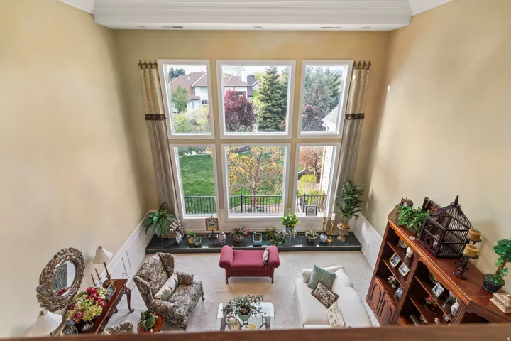 Living area featuring crown molding, carpet, and plenty of natural light