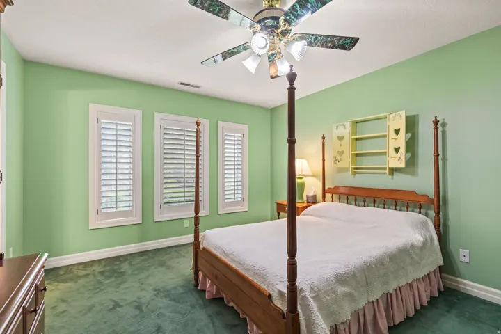 Bedroom featuring dark carpet and a ceiling fan