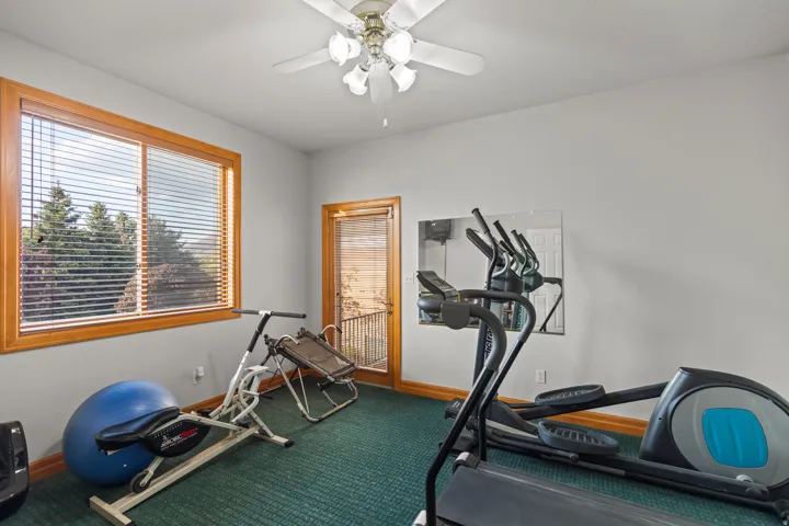 Workout area featuring ceiling fan and baseboards