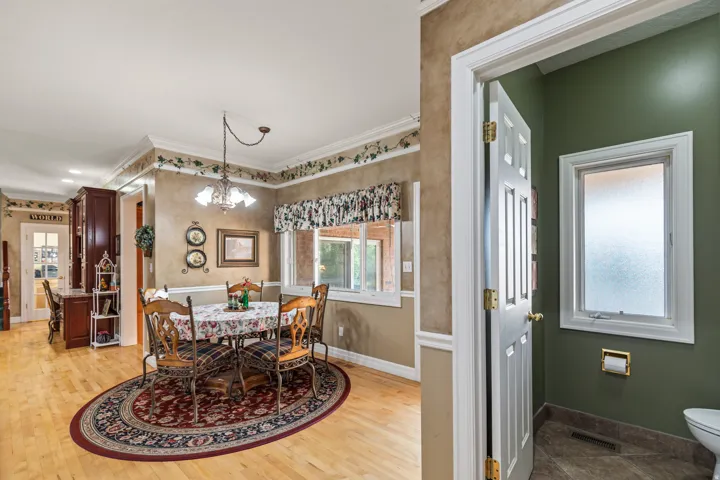 Dining space featuring hanging lights, ornamental molding, and light wood-style floors