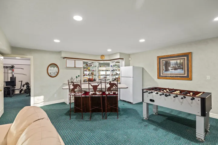 Recreation room featuring carpet flooring, recessed lighting, and a dry bar