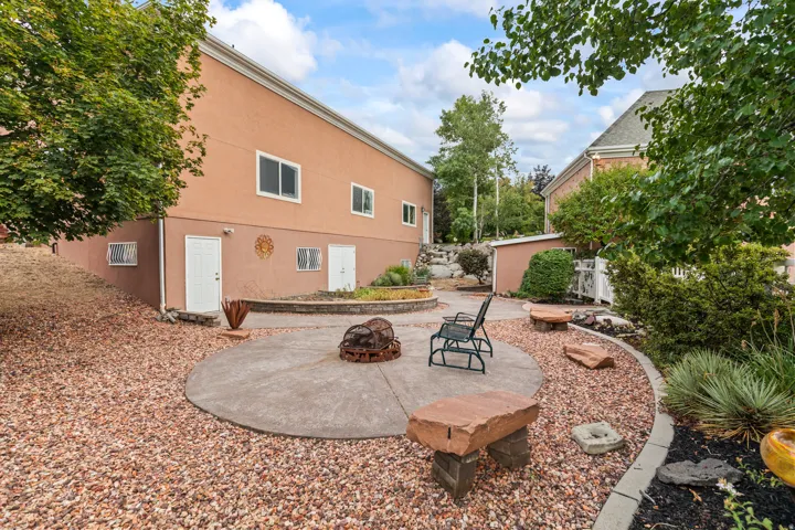 Back of house featuring a patio, a fire pit, and stucco siding