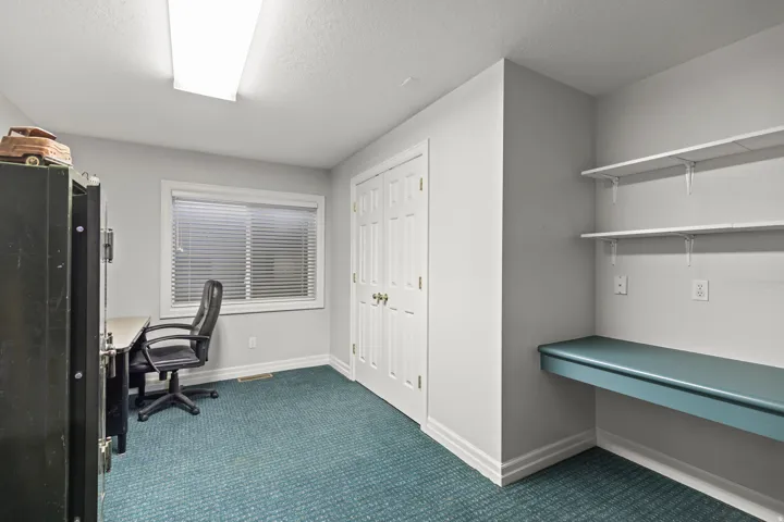 Office area featuring dark carpet and a textured ceiling