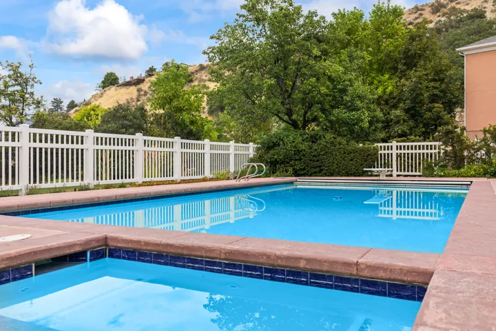 View of swimming pool with an in-ground hot tub, patio surround, and a mountain view