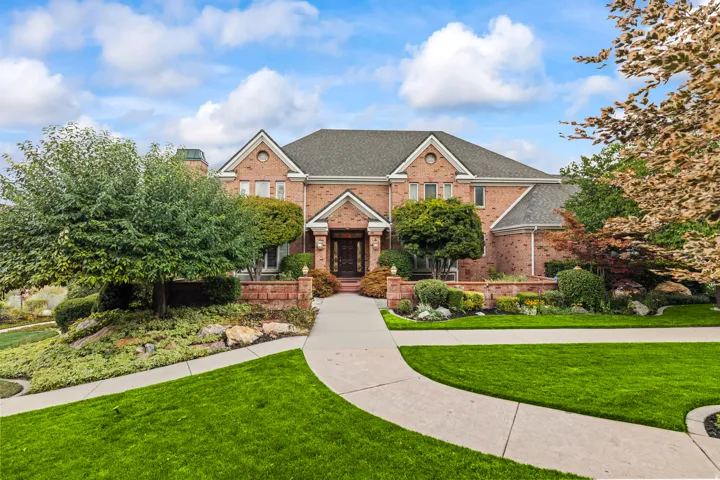 View of front of property featuring a front yard, brick siding, and a shingled roof