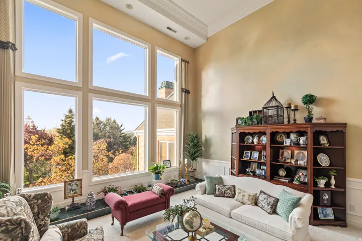 Carpeted living room featuring ornamental molding, a wainscoted wall, and a decorative wall