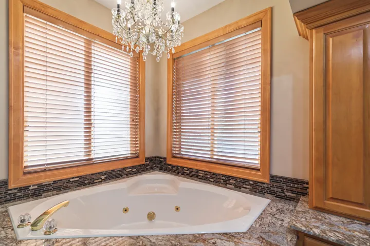 Full bath with hanging lights and a whirlpool tub