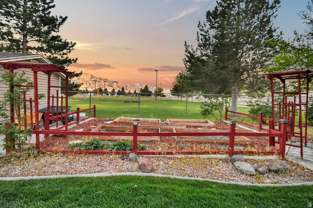 Landscaped garden beds with red fencing and trellises